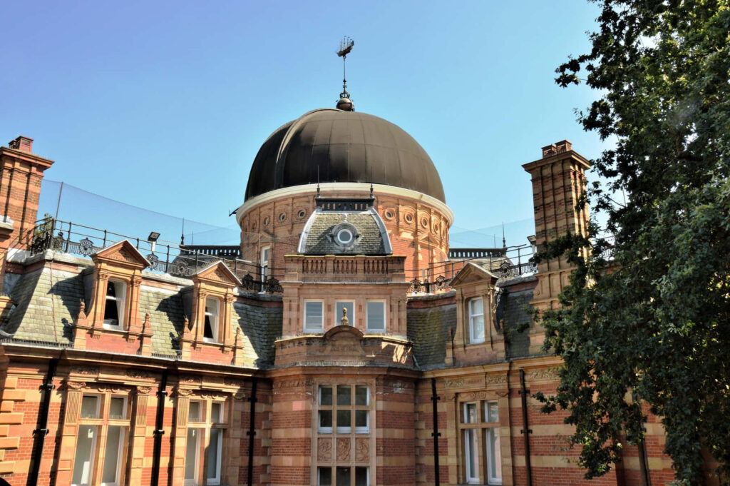 Historic Royal Observatory with grand dome and classic brick architecture under blue sky wallpaper