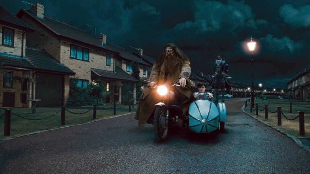 Rubeus Hagrid and Harry Potter on motorcycle sidecar driving through moody night street wallpaper