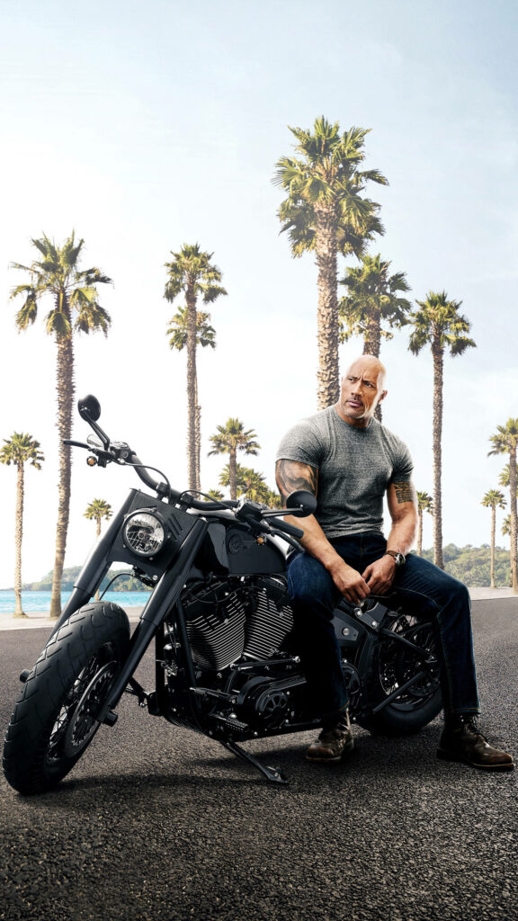 Dwayne Johnson Wallpaper: Rugged Charm on Motorcycle with Palm Trees