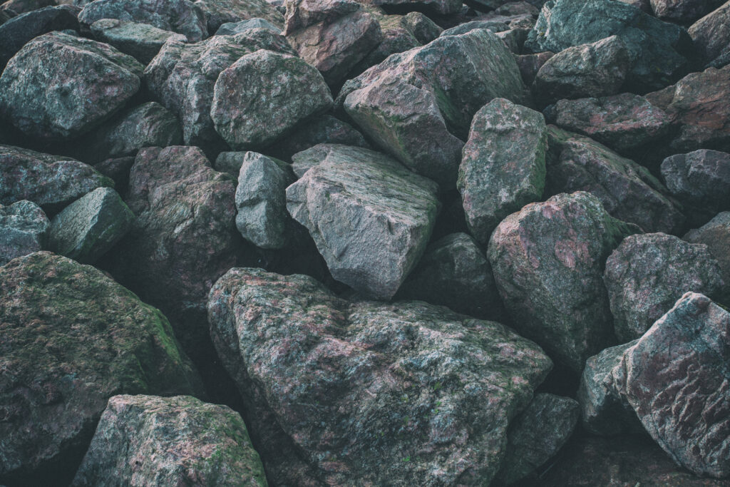 Rugged gray stone wall with rough textures and earthy tones nature-inspired wallpaper background