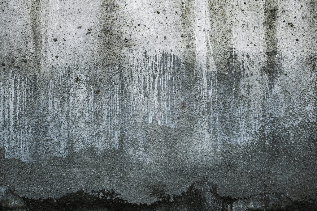 Rugged concrete wallpaper with gritty texture dark slate tones vertical mineral streaks industrial