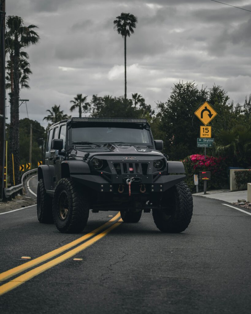Rugged Jeep on Winding Road: Adventure Awaits in Nature's Paradise Wallpaper