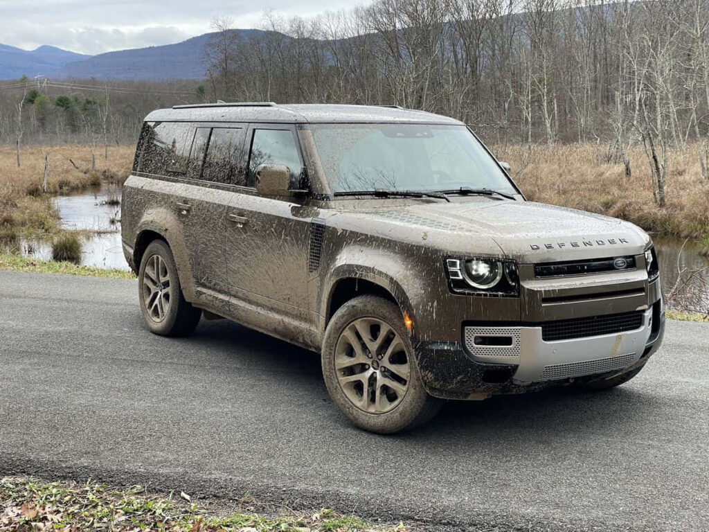 Rugged Land Rover Defender Wallpaper: Muddy Adventure Near Creek
