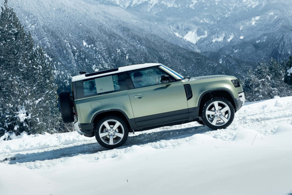 Rugged Land Rover Defender: Snowy Mountain Off-Road Wallpaper