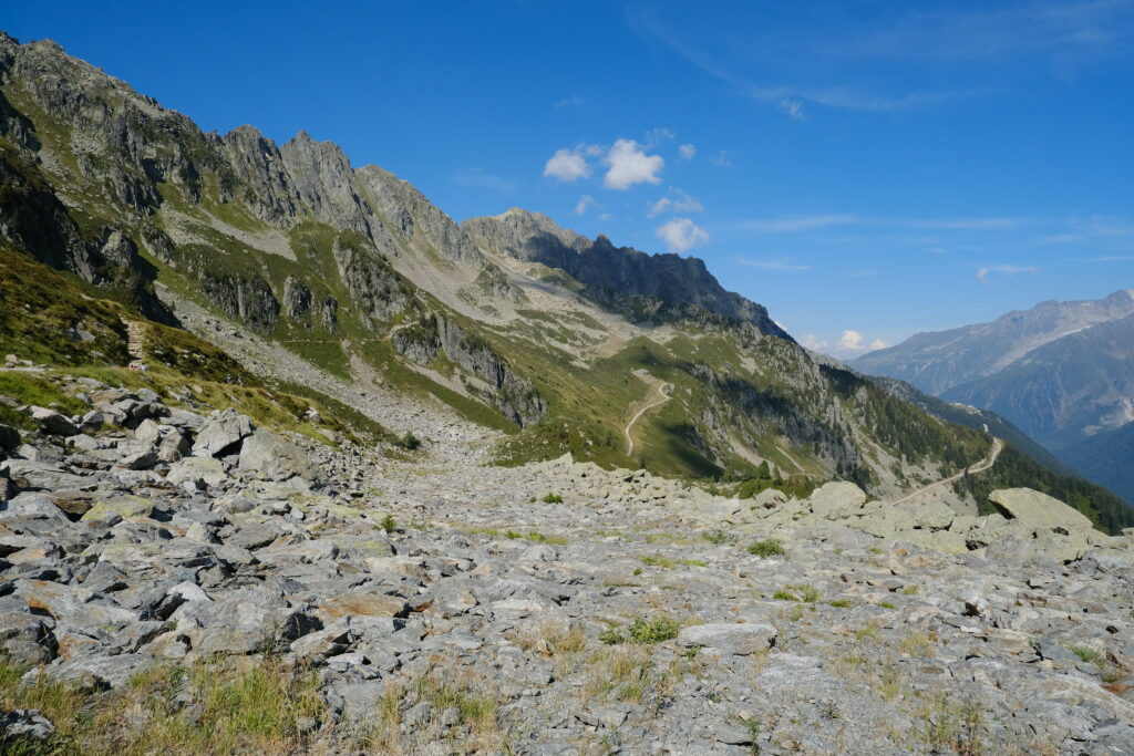Rugged mountain landscape with jagged peaks clear sky winding rocky path wilderness wallpaper