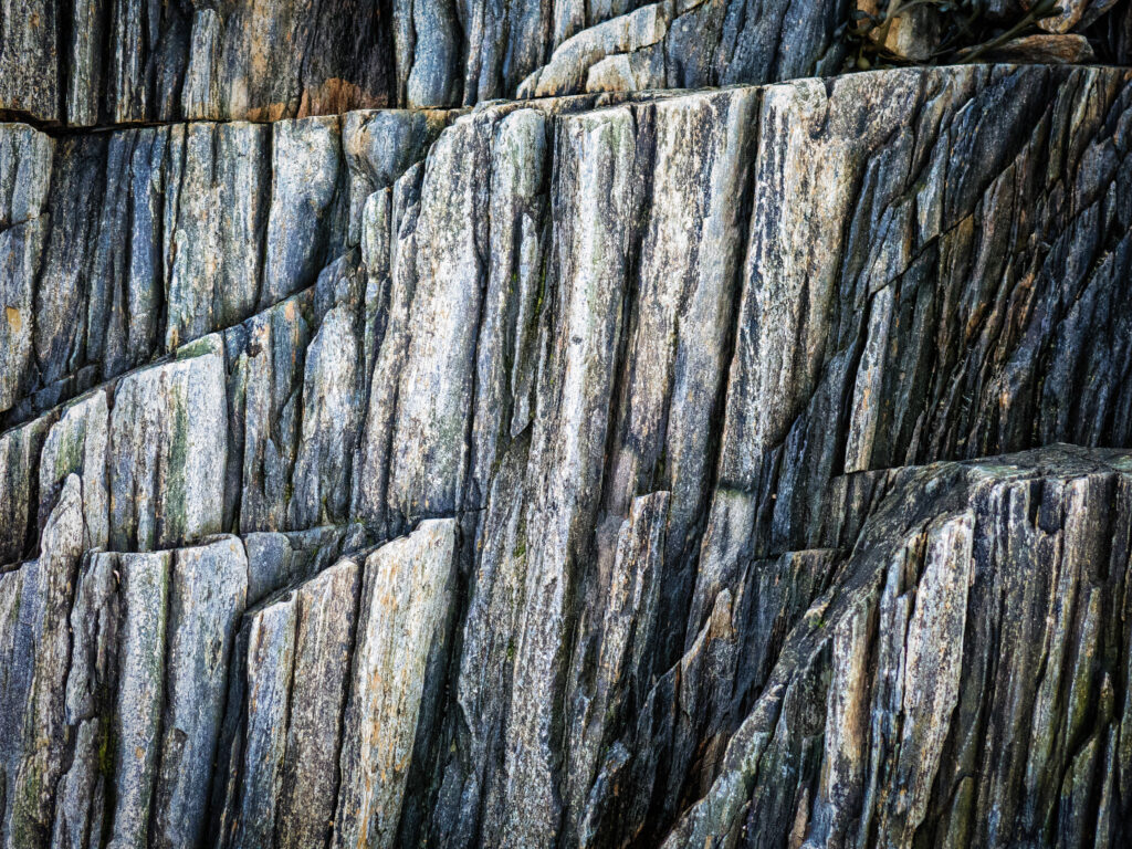 Close up of rugged gray and blue stone texture with layered natural rock patterns background Wallpaper