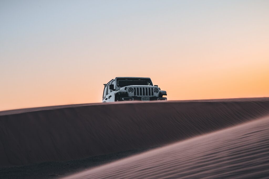 Rugged SUV Against Stunning Desert Sunset - Adventure Awaits! Wallpaper