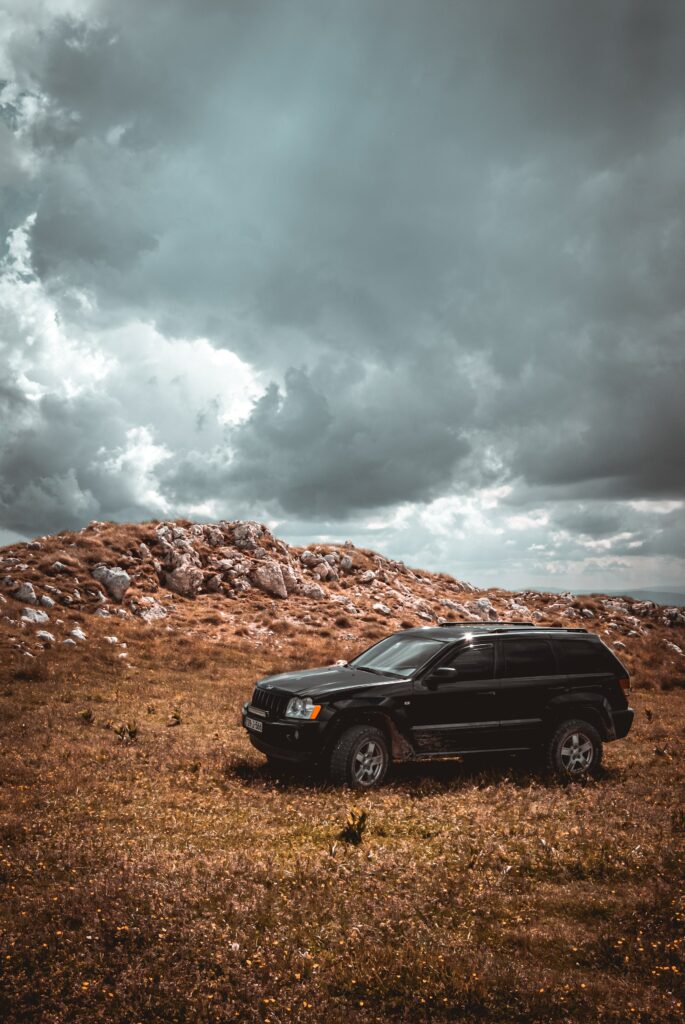 Rugged SUV Off-Road Wallpaper with Dramatic Sky and Terrain
