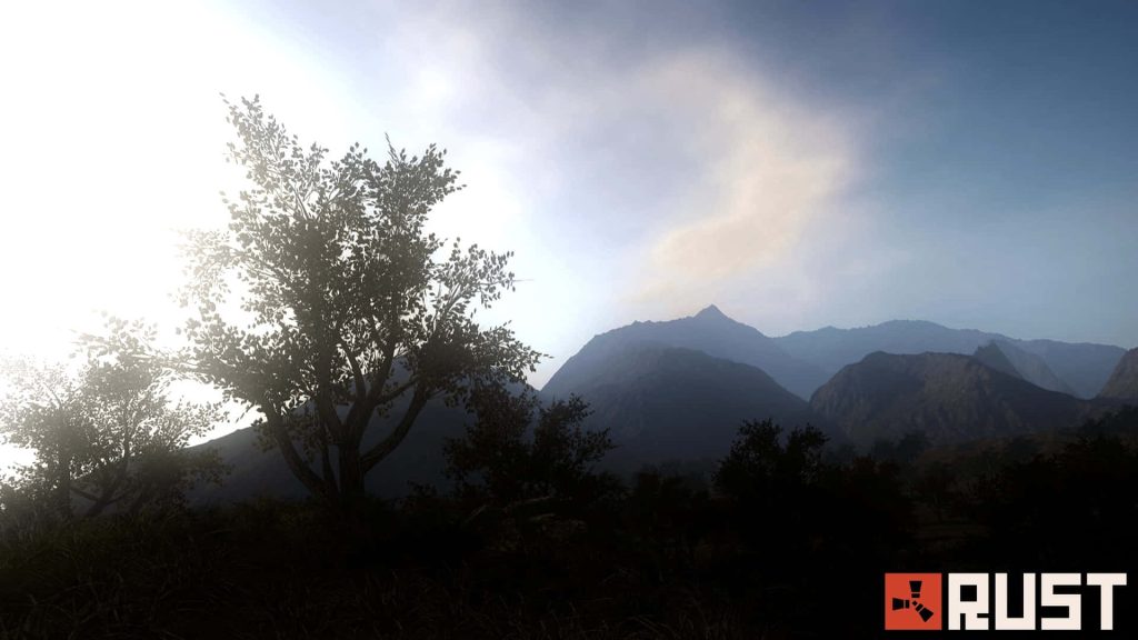 Silhouetted tree and hazy mountain Rust game wallpaper with bright sun and cinematic atmosphere