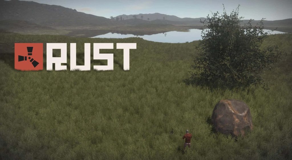 Rust game wallpaper lone player in red hoodie near resource node in grassy open world