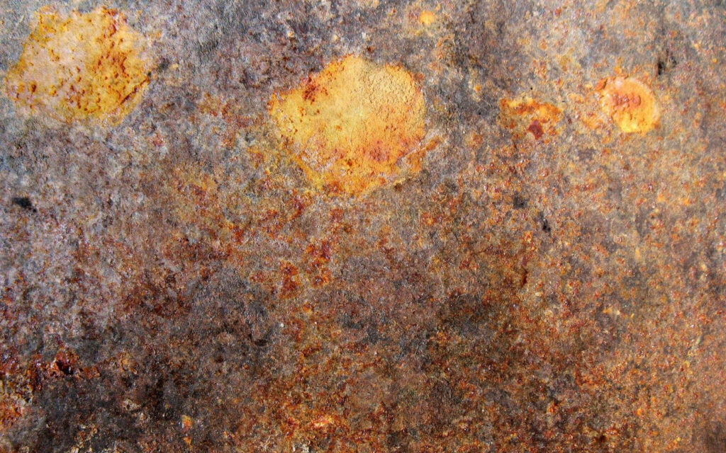 Rust-Tinged Iron Surface Wallpaper: Textured Metal Close-Up