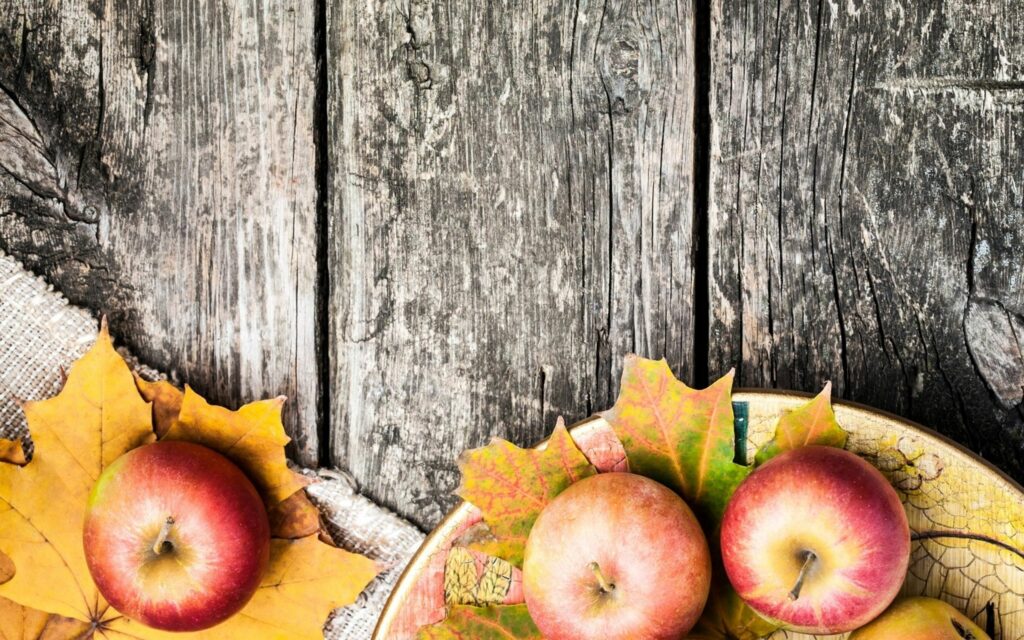 Rustic Wooden Table with Autumn Leaves & Apples - Cozy Wallpaper