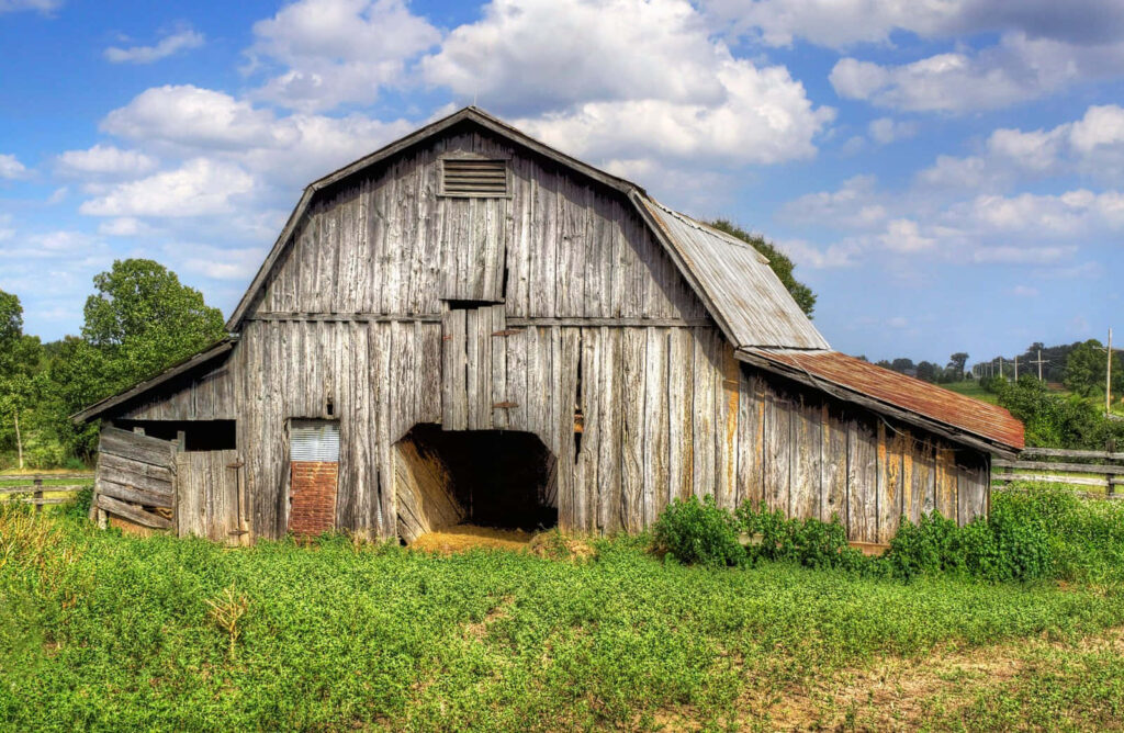 Rustic Barn Wallpaper: Serene Green Landscape & Blue Sky Background