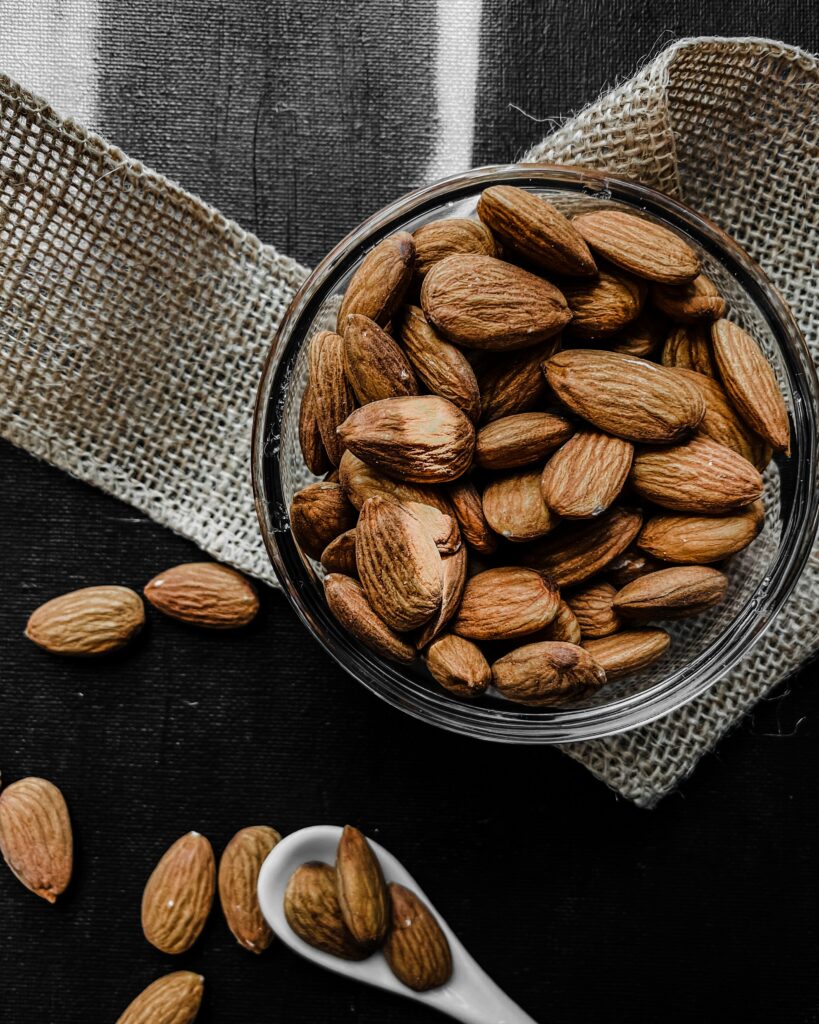 Rustic Almond Bowl on Textured Fabric | Dark Wallpaper Background