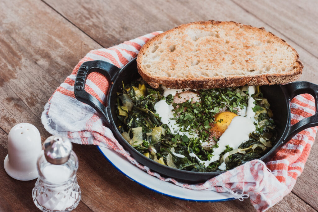 Rustic Breakfast Setting: Cast-Iron Skillet, Eggs & Cozy Vibes Wallpaper