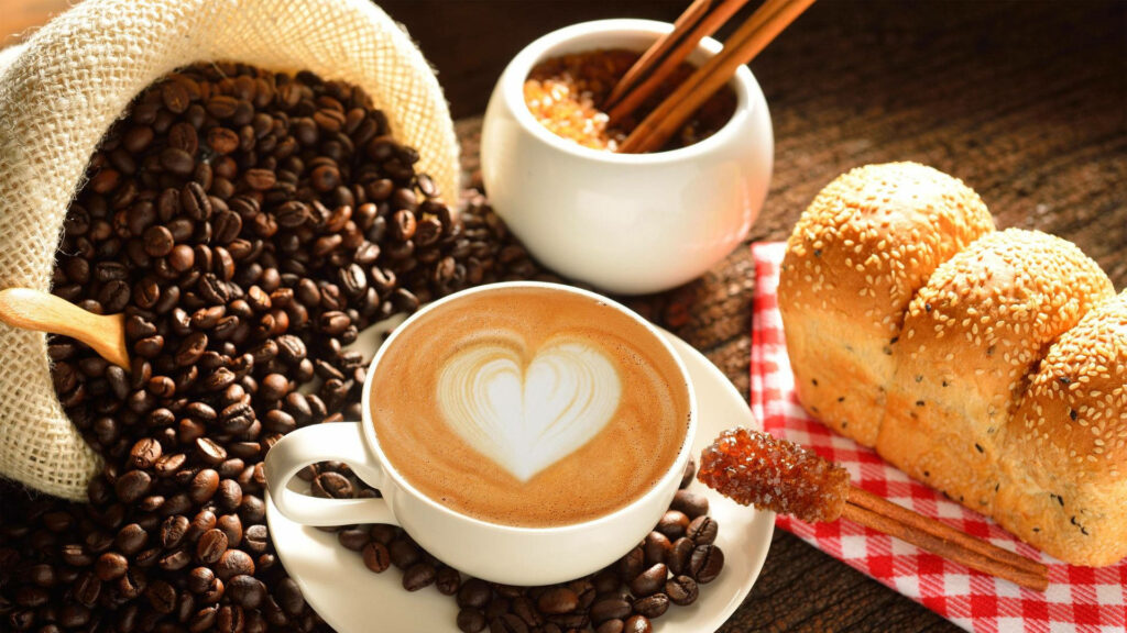 Rustic breakfast scene with sesame bread latte heart foam coffee beans brown sugar wooden table Wallpaper