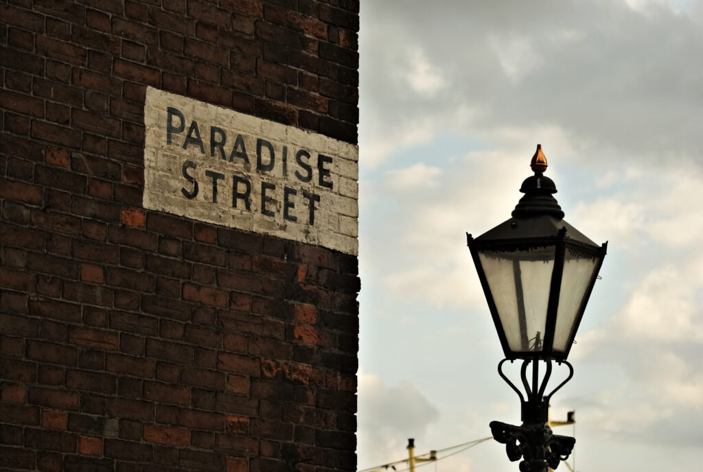 Vintage Urban Wallpaper: Rustic Brick Wall with Paradise Street Sign