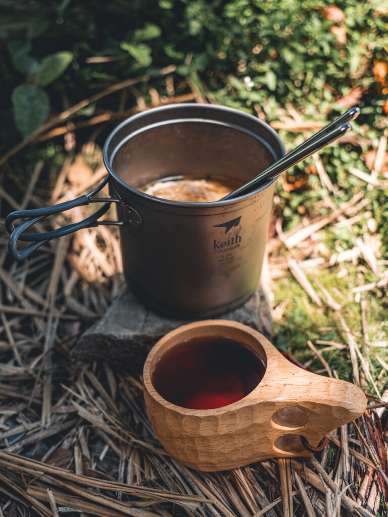 Rustic Camping Scene: Kettle & Mug in Nature - Wallpaper Background