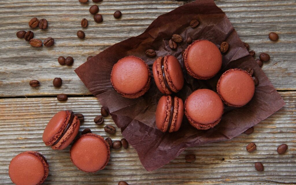 Rustic Chocolate Macarons on Parchment with Coffee Beans Wallpaper