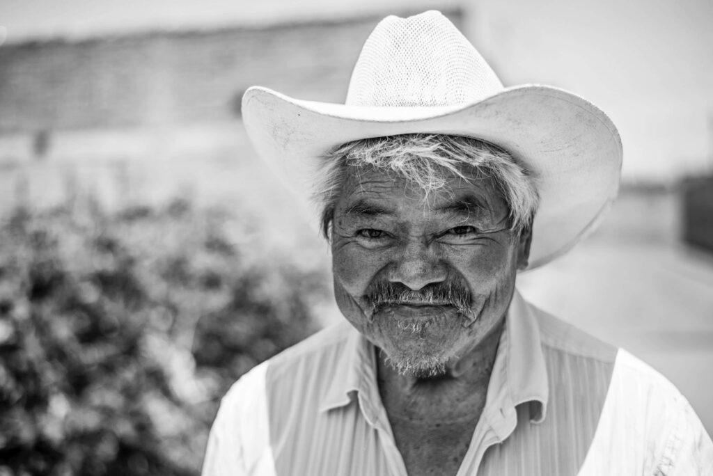 Mature Man in Cowboy Hat: Timeless Black & White Nature Photography Wallpaper