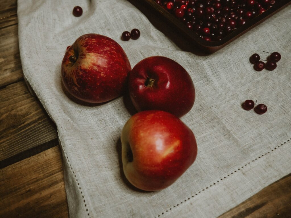 Cozy Rustic Wallpaper with Vibrant Red Apples & Cranberries Background
