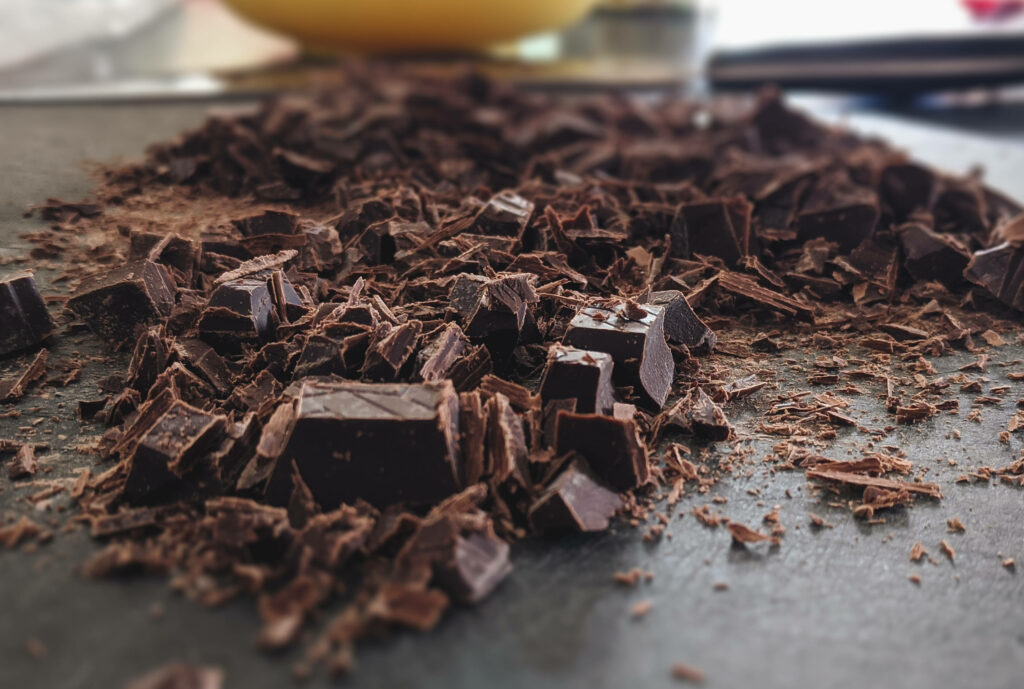 Close-up of rich crushed chocolate pieces on dark surface with textured detailed background Wallpaper
