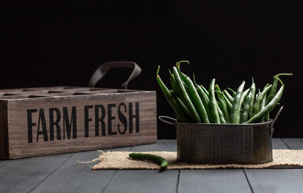 Rustic farmhouse wallpaper with fresh green beans in pot and farm fresh crate on burlap runner