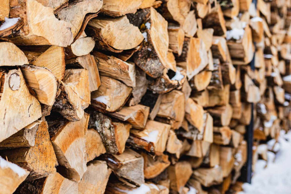 Rustic Charm: Neatly Stacked Firewood Wallpaper with Warm Tones