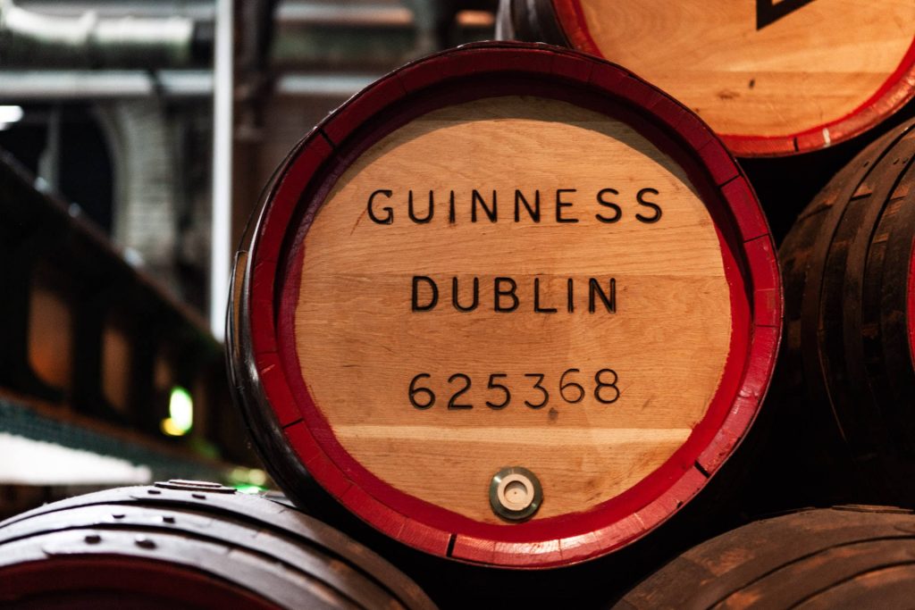 Close-up of rustic wooden Guinness barrel with red rims at historic St James's Gate Brewery Dublin Wallpaper