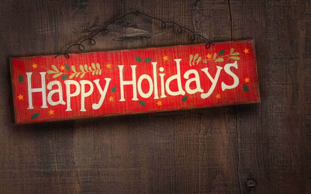 Rustic red Happy Holidays sign with holly stars on textured wood background festive wallpaper