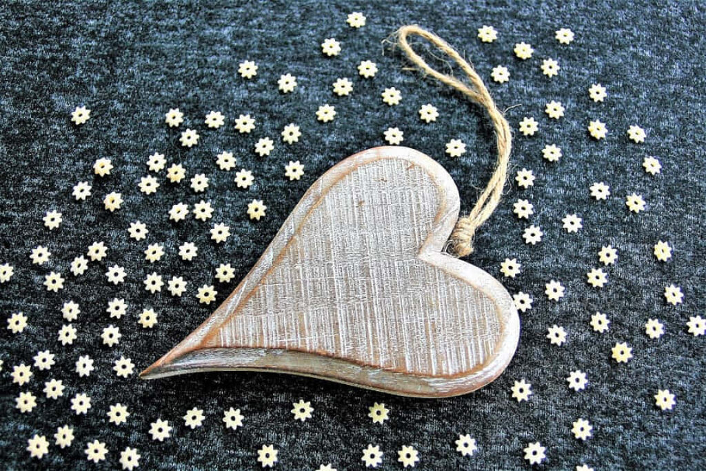 Rustic Wood Heart Ornament on Gray Surface with Flower Accents Wallpaper