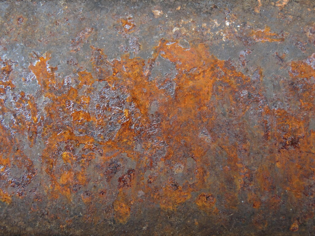 Rustic industrial wallpaper with detailed old charcoal steel texture and vibrant orange rust patches