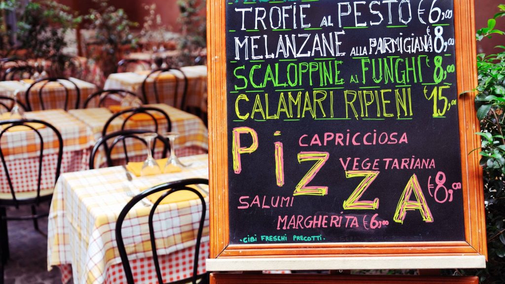 Rustic Italian trattoria chalkboard menu with colorful dishes and cozy yellow checkered tables Wallpaper