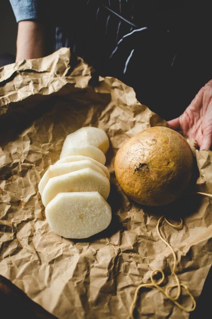 Rustic jícama with fresh slices on brown paper warm natural textures food wallpaper background