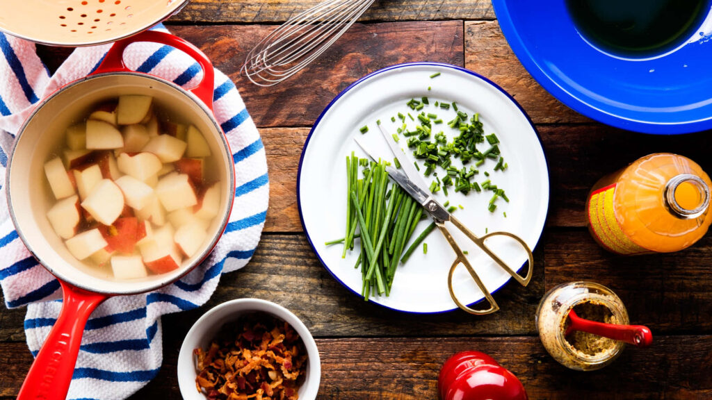 Rustic Kitchen Scene: Wooden Table with Ingredients & Utensils Wallpaper