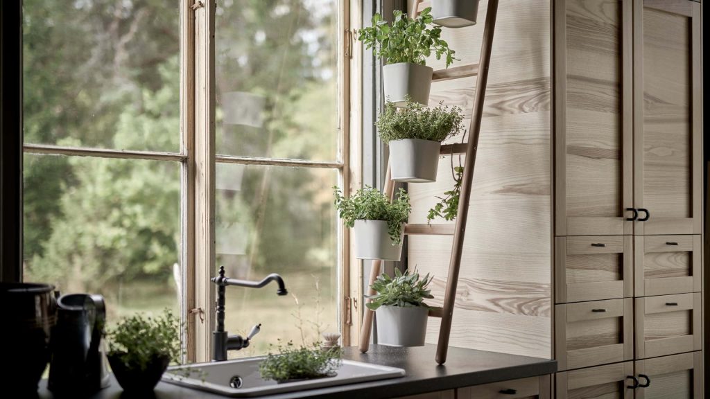 Rustic kitchen wallpaper with ladder shelf holding green herbs and warm wood cabinets