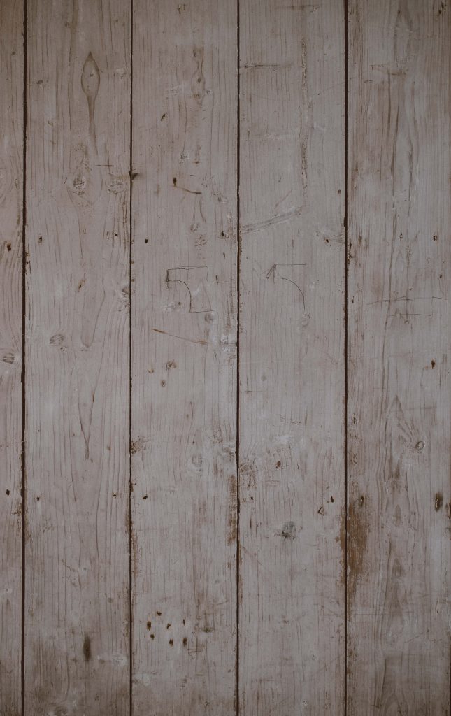 Close-up of weathered light grey vertical wooden panels with natural grain and knots texture Wallpaper