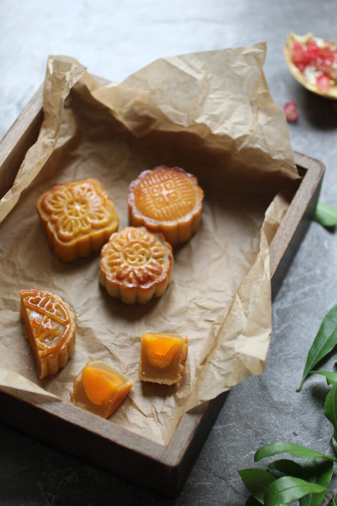 Rustic Mooncake Display: Exquisite Golden Brown Treats on Parchment Wallpaper