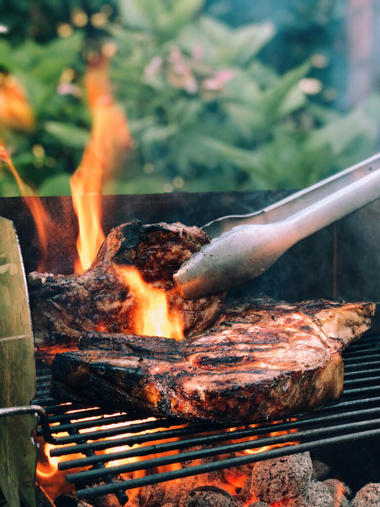 Rustic Outdoor Parrilla Grill: Sizzling Steak Cooking Wallpaper