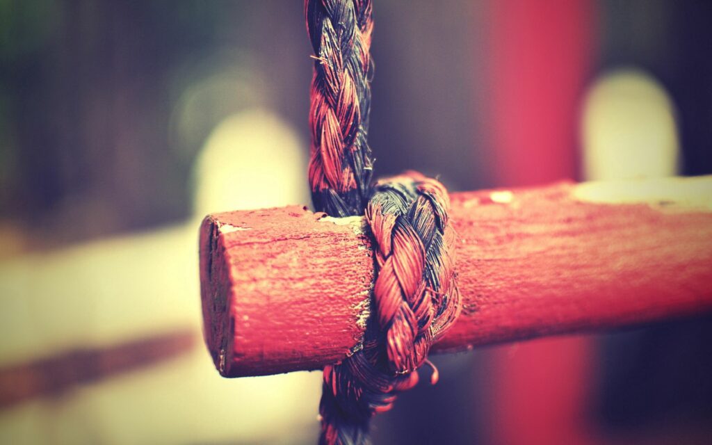 Rustic Red Wooden Beam with Black Rope Wallpaper Background
