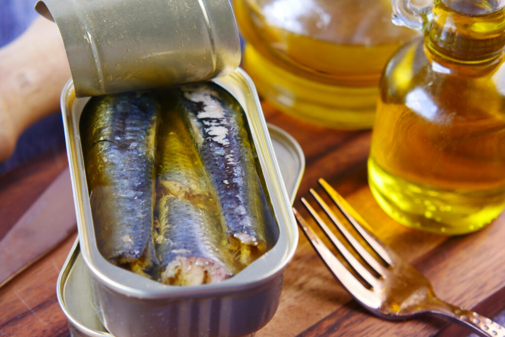 Rustic Sardines in Olive Oil: Close-Up Can and Wooden Surface Wallpaper