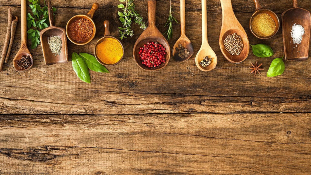 Rustic Spice Background: Turmeric & Fresh Herbs on Wood Wallpaper