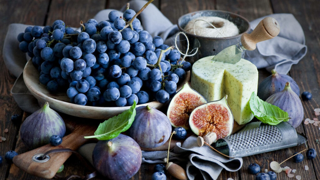 Rustic still life of fresh blueberries figs and herbed cheese on wooden table cozy background Wallpaper