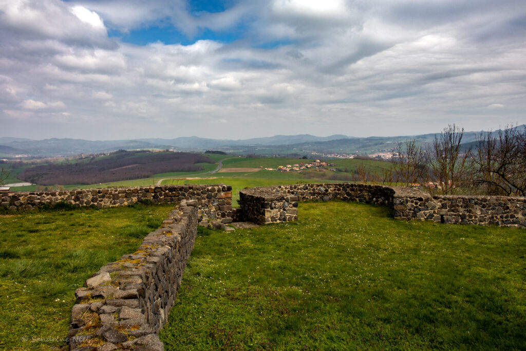 Rustic stone fence in lush green valley with rolling hills and partly cloudy sky wallpaper background
