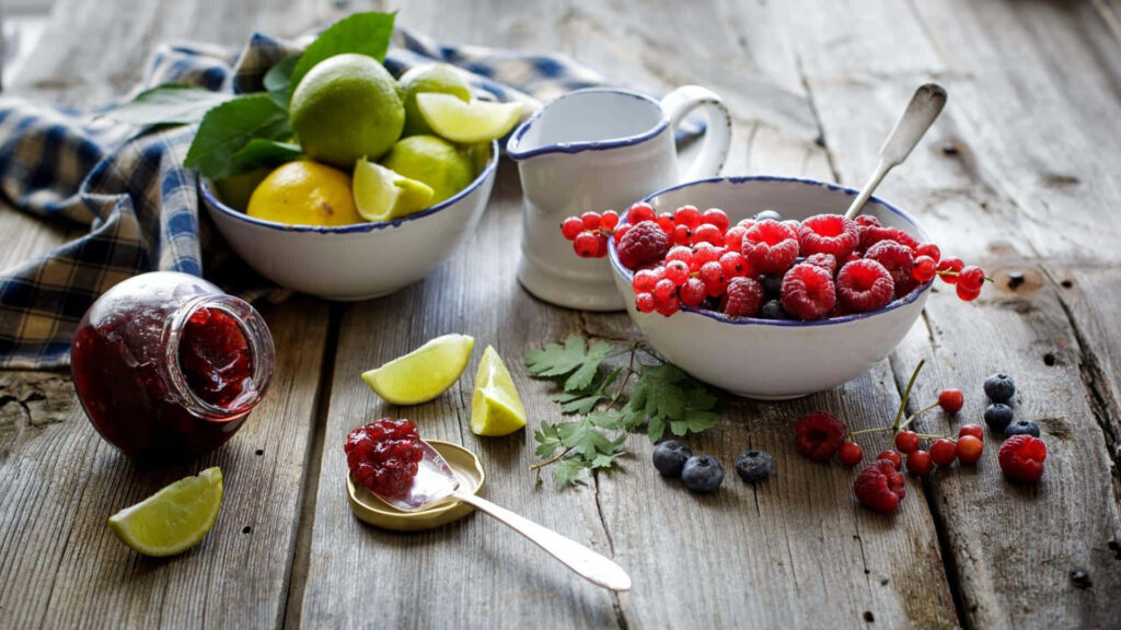 Vibrant Rustic Tabletop: Fresh Fruits, Jam, and Spoon Wallpaper