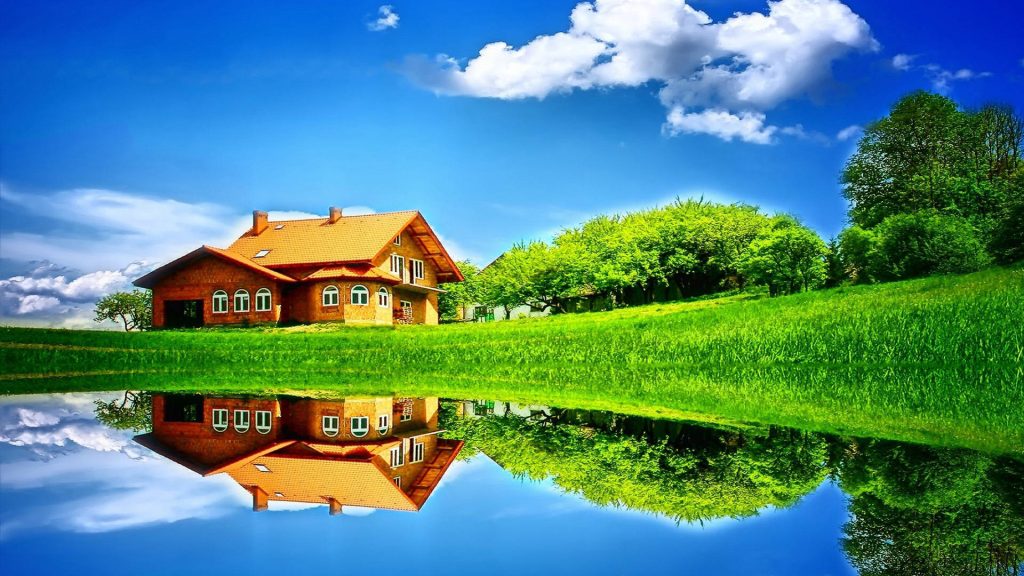 Rustic terracotta roof house reflected in calm water with green meadow and clear blue sky HD wallpaper