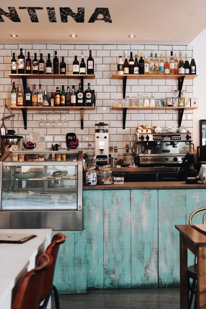 Cozy cafe wallpaper with turquoise wooden counter white subway tile espresso machine shelves