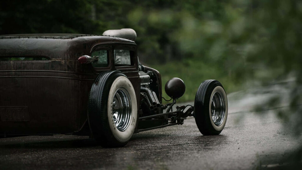 Vintage Car on Wet Road: Rustic Charm & Lush Greenery Wallpaper