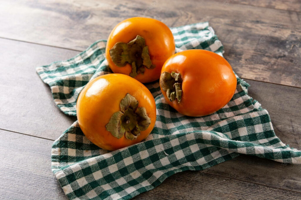 Rustic Wallpaper: Fresh Persimmons on Green Checkered Cloth