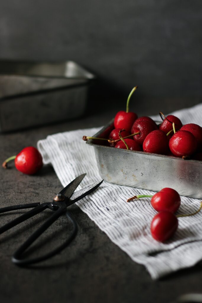 Rustic Wallpaper: Fresh Red Cherries in Metal Container Background
